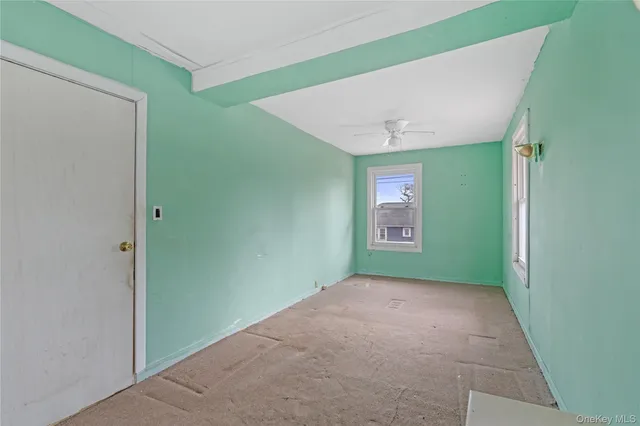 a view of an empty room with window and stairs