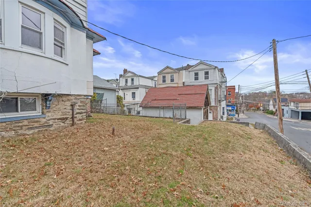a view of a white house with large windows and a table and chairs