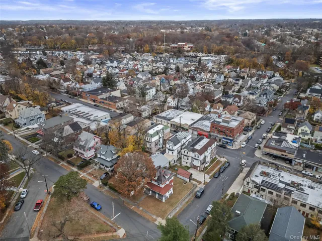 a view of a white house with a large tree