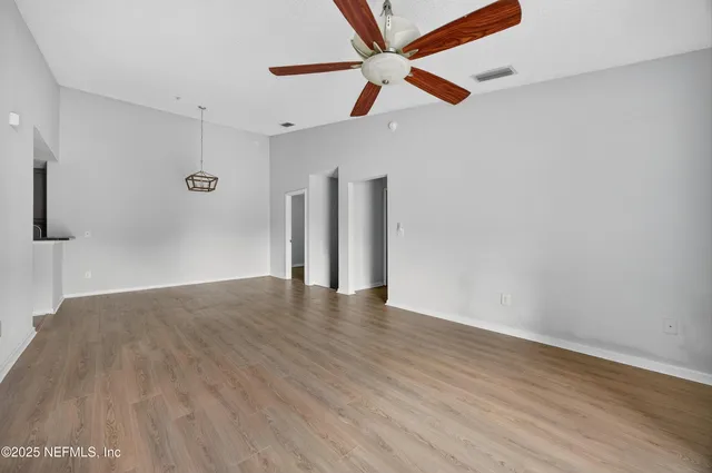 a view of an empty room with wooden floor
