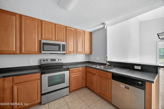 a kitchen with stainless steel appliances granite countertop a sink stove and microwave