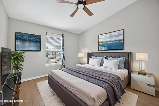 a bedroom with bed and a painting on the wall