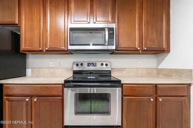 a kitchen with granite countertop wooden cabinets and a stove top oven