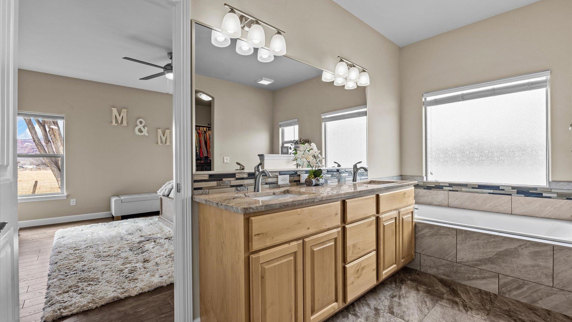 686 Beech Avenue Fruita, CO 81521 - Photo 20 of 33 a bathroom with a granite countertop sink a large mirror and a bathtub