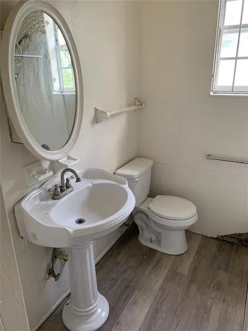 a bathroom with a toilet a sink and a mirror