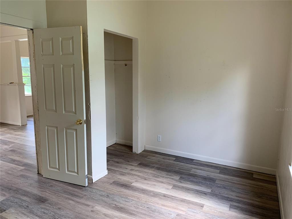 417 Maple Street Daytona Beach, FL 32114 - Photo 3 of 7 an empty room with wooden floor and a door
