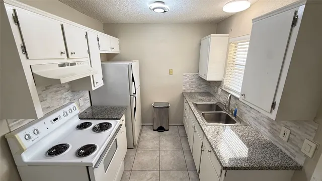 a kitchen with a refrigerator sink and stove