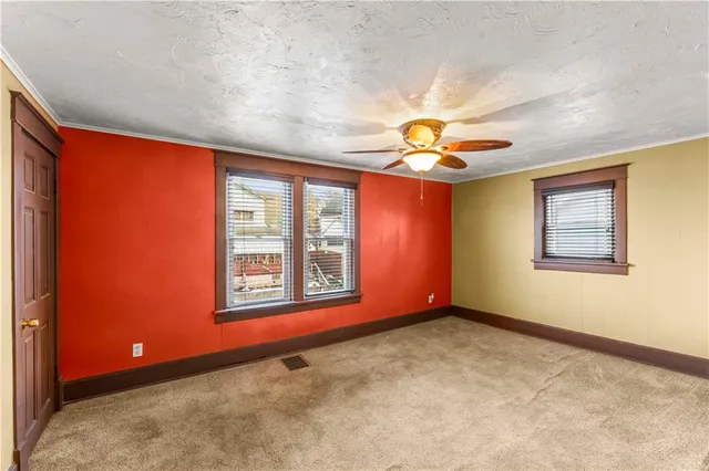 an empty room with a window and a ceiling fan