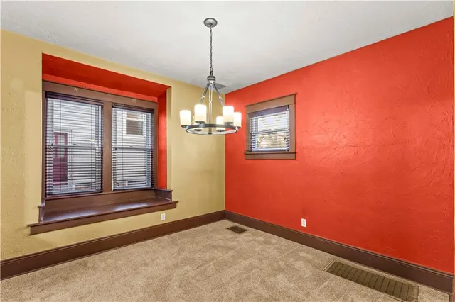 a view of a livingroom with a chandelier fan and windows
