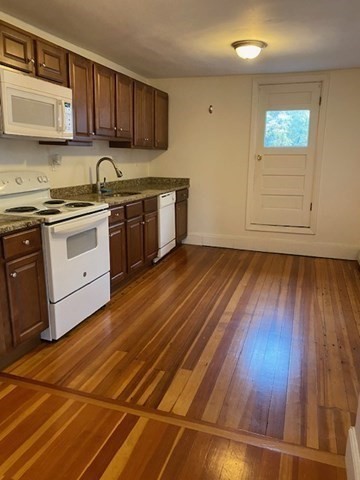 45 Webster Street, Unit 2 Woburn, MA 01801 - Photo 4 of 10 a kitchen with wooden floors and cabinets