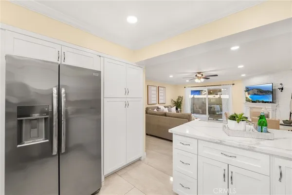 a kitchen with stainless steel appliances kitchen island granite countertop a refrigerator and a sink