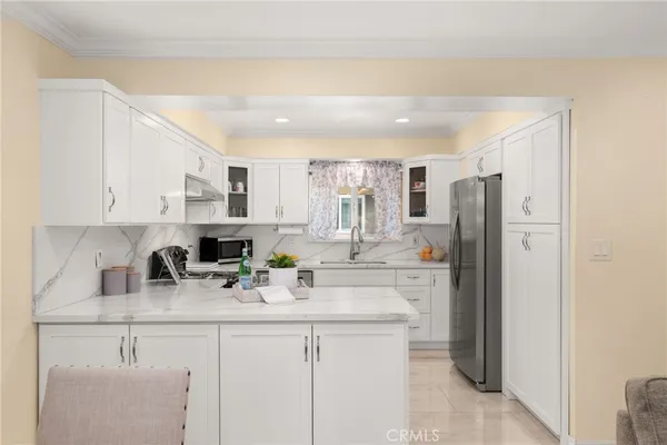 a kitchen with stainless steel appliances a sink stove refrigerator and cabinets