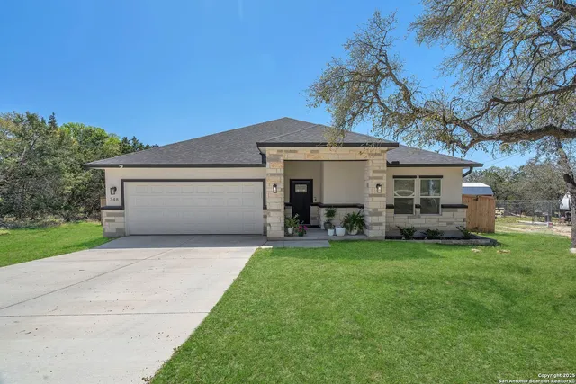 a front view of a house with a garden and yard