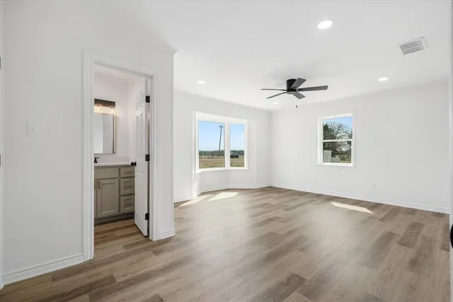 an empty room with wooden floor and a window
