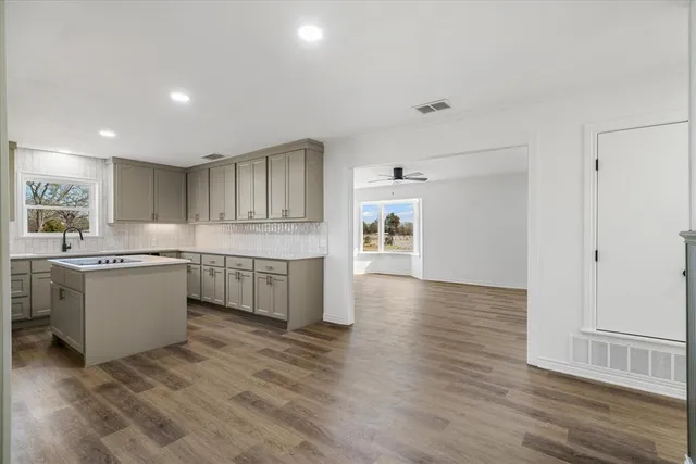 a kitchen with granite countertop a stove top oven sink and cabinets