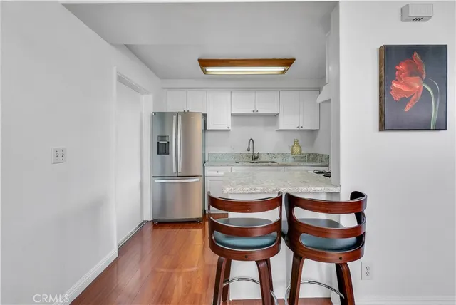 a kitchen with granite countertop stainless steel appliances and wooden floor