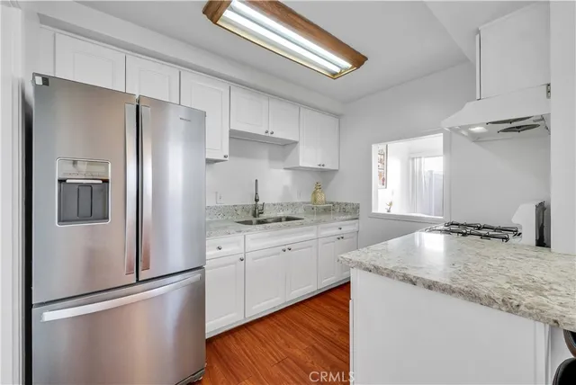 a kitchen with granite countertop stainless steel appliances a refrigerator a sink and a stove
