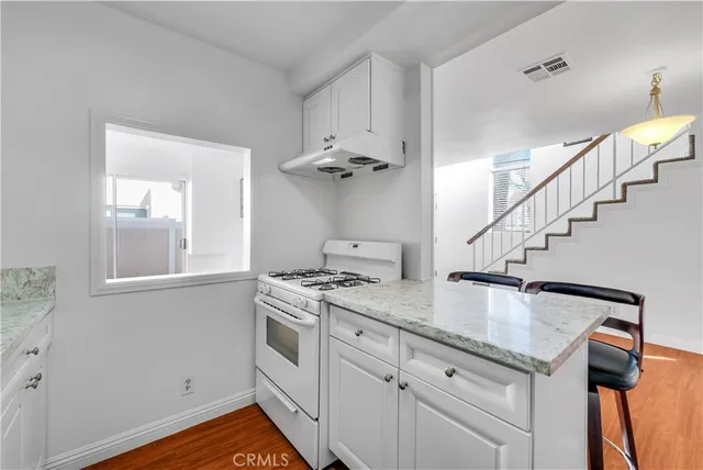 a view of a kitchen counter space with wooden floor and fan