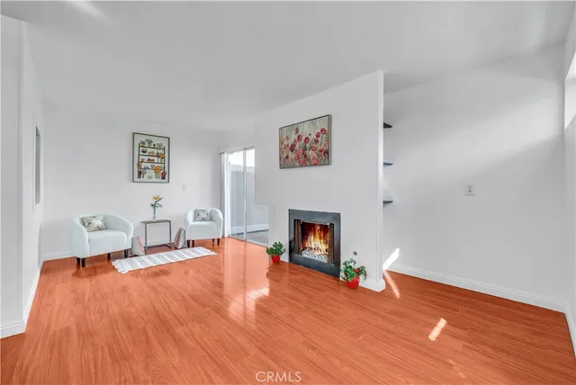 a living room with a fireplace and wooden floor