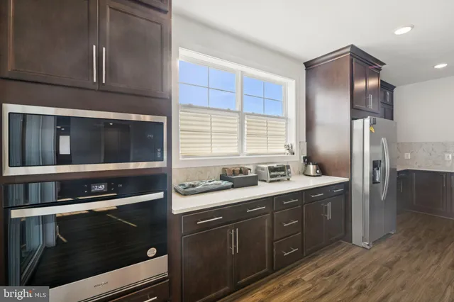 a large kitchen with stainless steel appliances granite countertop a stove a sink and a refrigerator