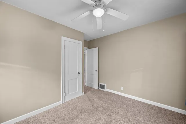 an empty room with a chandelier fan and a chandelier fan