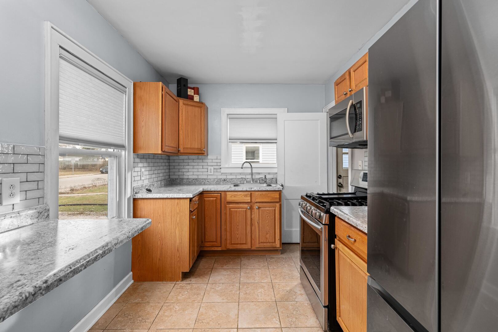 2517 3rd Street East Moline, IL 61244 - Photo 8 of 22 a kitchen with stainless steel appliances granite countertop a sink stove and refrigerator