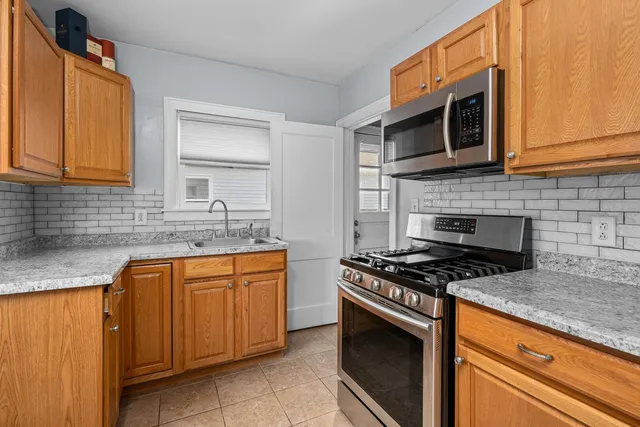 a kitchen with stainless steel appliances granite countertop a sink stove and microwave