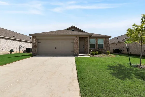 a front view of a house with a yard and a garage