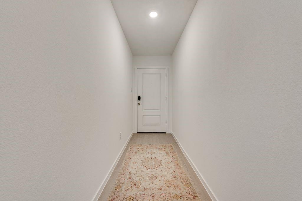 14112 Hammersmith Street Pilot Point, TX 76258 - Photo 3 of 19 a view of a hallway with a white wall and a window