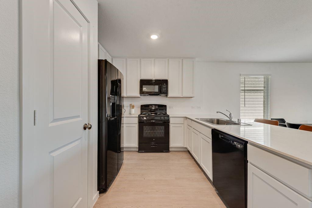 14112 Hammersmith Street Pilot Point, TX 76258 - Photo 5 of 19 a kitchen with stainless steel appliances granite countertop a refrigerator and a stove top oven