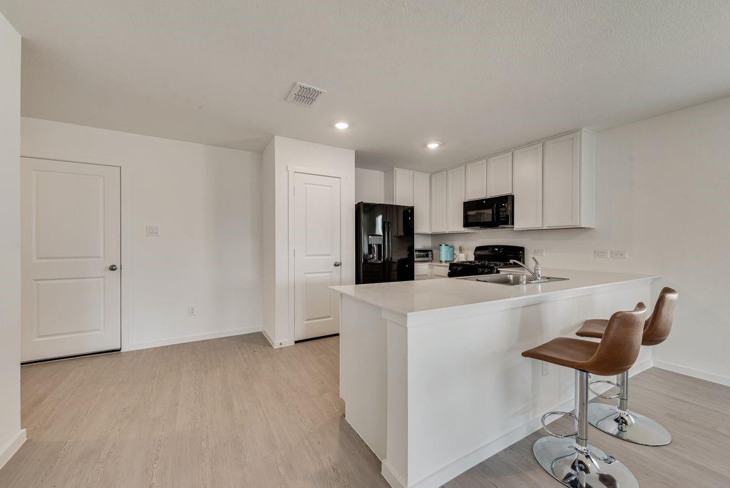 14112 Hammersmith Street Pilot Point, TX 76258 - Photo 7 of 19 a kitchen with stainless steel appliances kitchen island granite countertop a refrigerator and a stove top oven