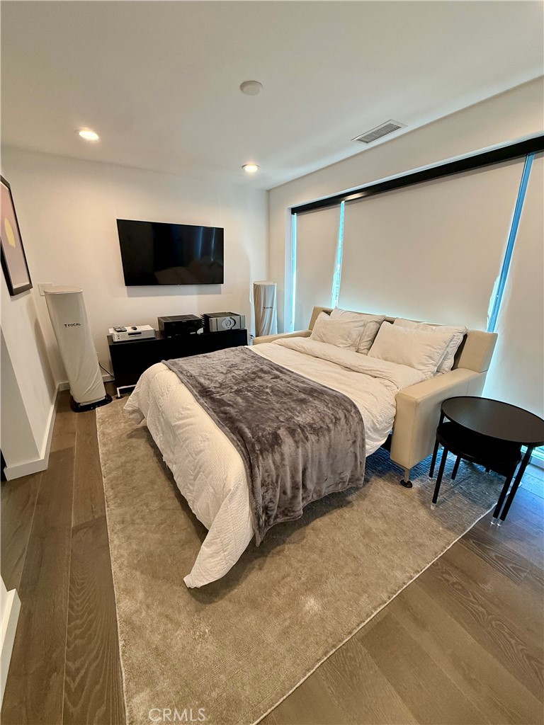 116 West Channel Islands Boulevard Oxnard, CA 93035 - Photo 34 of 60 a bedroom with a bed a flat screen tv and a couch