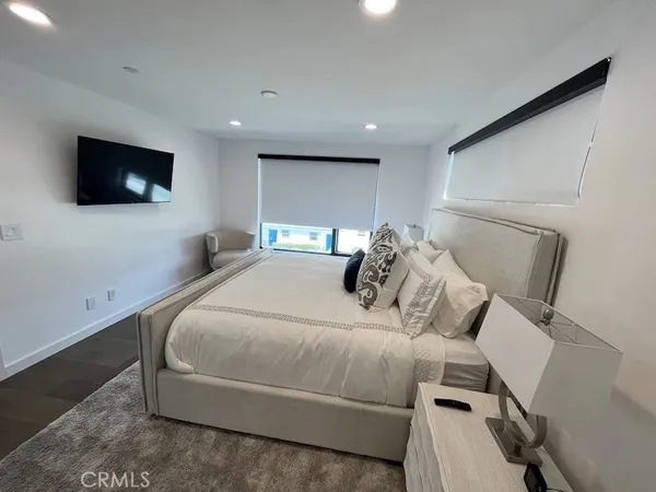 a living room with furniture flat screen tv and floor to ceiling window