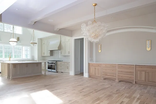 a view of an empty room with wooden floor and a cabinet