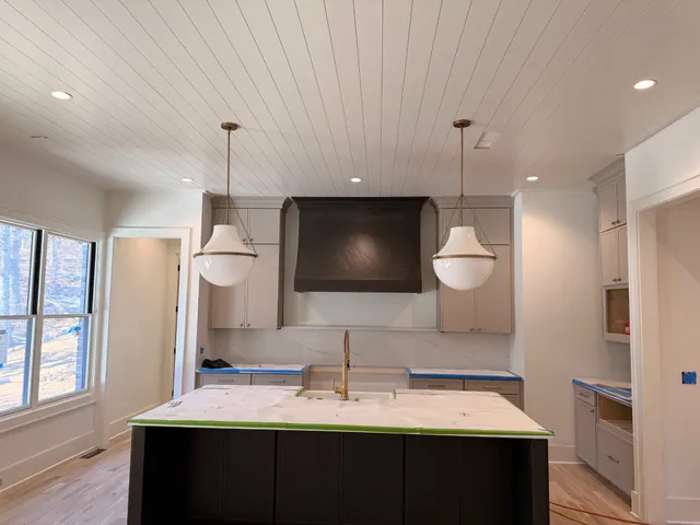 a spacious bedroom with a large bed and a chandelier