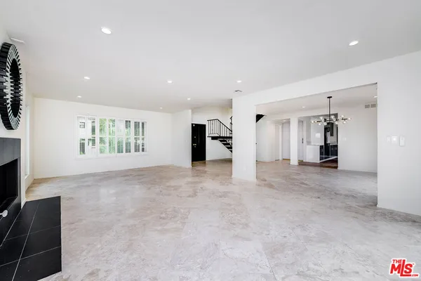a view of an empty room with closet and a window