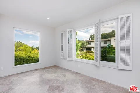 a view of an empty room with a window and a room