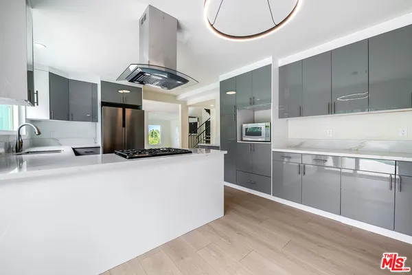 a kitchen with stainless steel appliances granite countertop a sink a stove and a refrigerator