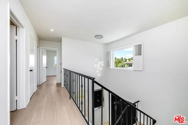 a view of a hallway with wooden floor and staircase