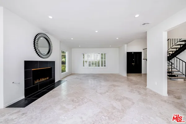 a view of an empty room with a fireplace and a window