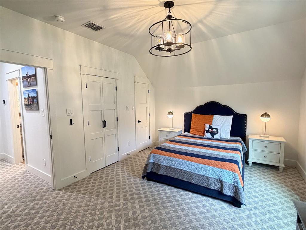 1304 Tinker Road Colleyville, TX 76034 - Photo 18 of 28 a bedroom with a bed and a chandelier