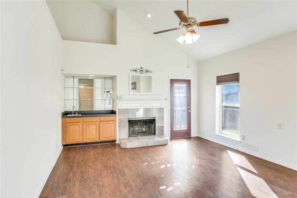 2151 Falcon Ridge Drive Carrollton, TX 75010 - Photo 7 of 40 a view of a livingroom with a fireplace a ceiling fan and windows