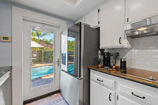 a kitchen with granite countertop white cabinets and stainless steel appliances