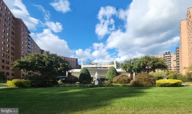 a view of a white house with a big yard and potted plants