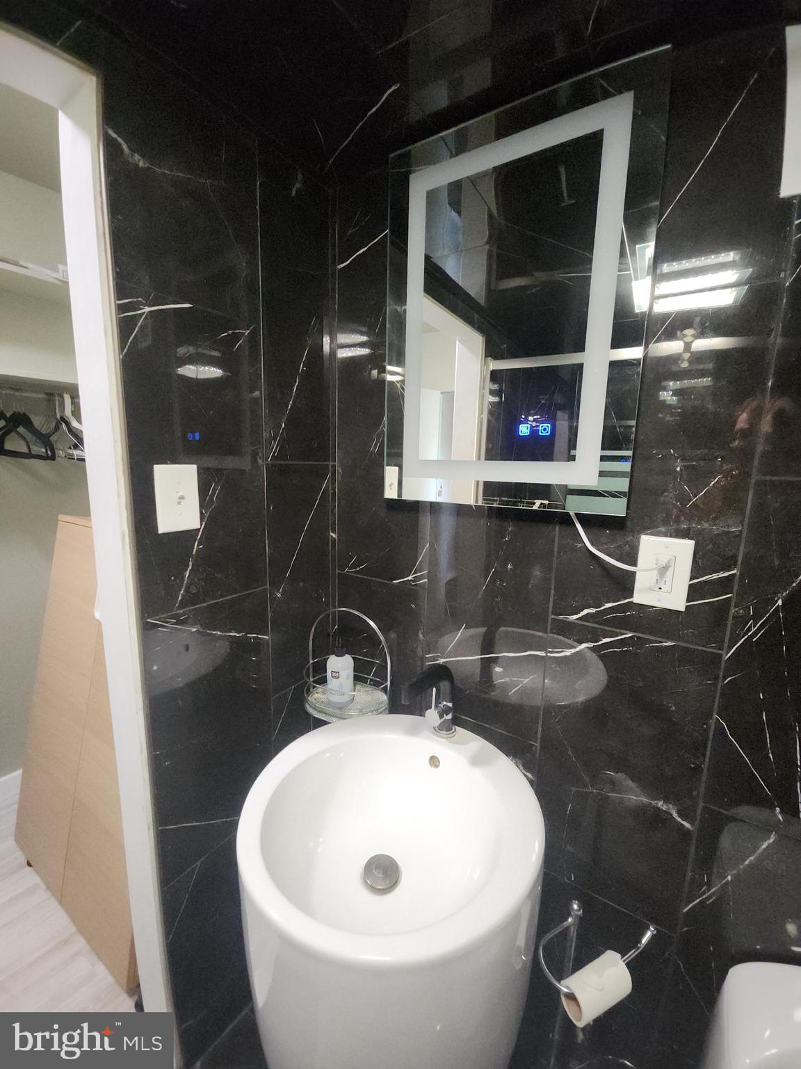 4201 Cathedral Avenue Northwest, Unit 1418E Washington, DC 20016 - Photo 15 of 17 a bathroom with a sink and mirror