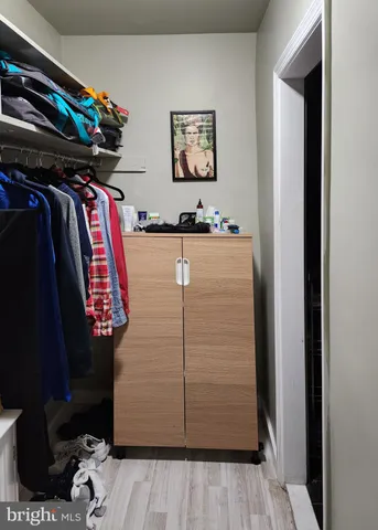 a view of walk in closet with clothes and shoes