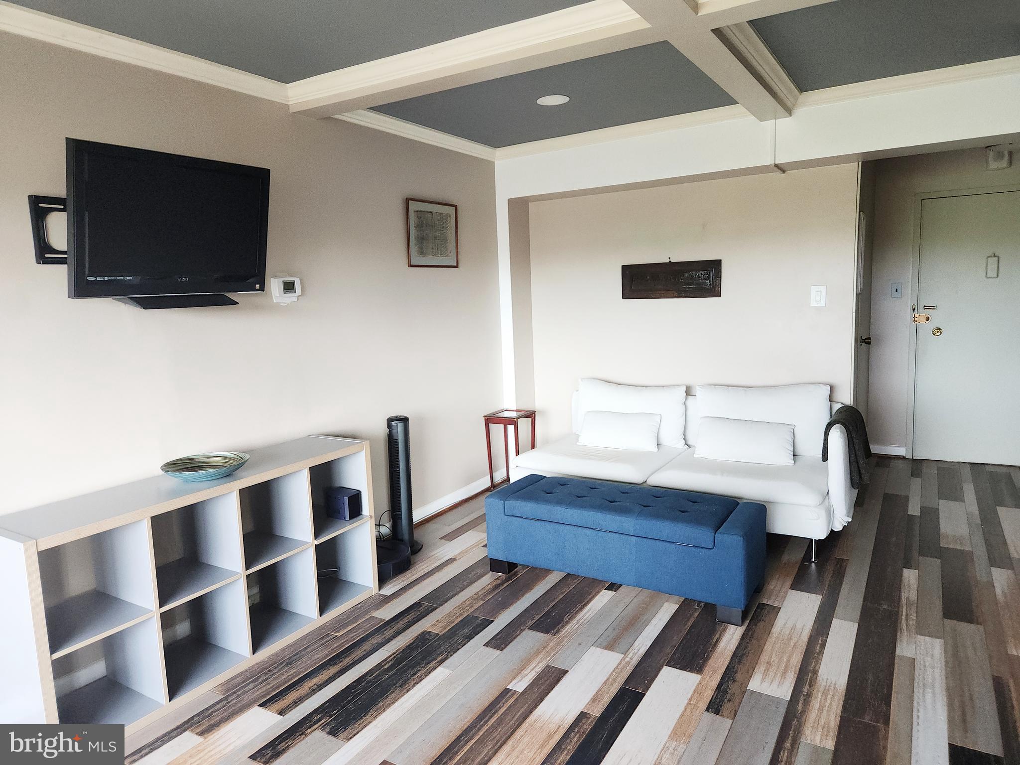 4201 Cathedral Avenue Northwest, Unit 1418E Washington, DC 20016 - Photo 2 of 17 a living room with furniture and a flat screen tv