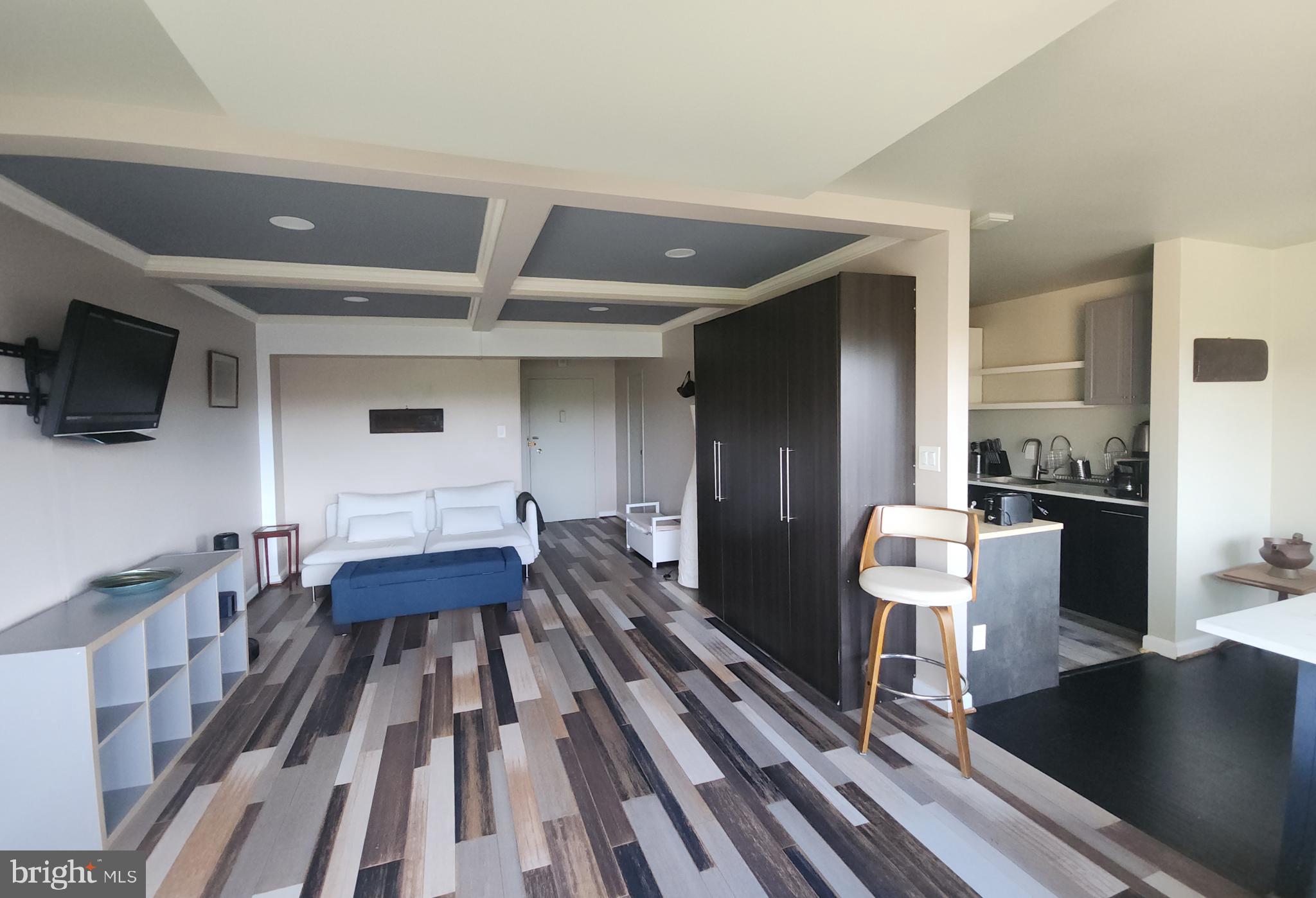 4201 Cathedral Avenue Northwest, Unit 1418E Washington, DC 20016 - Photo 3 of 17 a living room with furniture and a flat screen tv