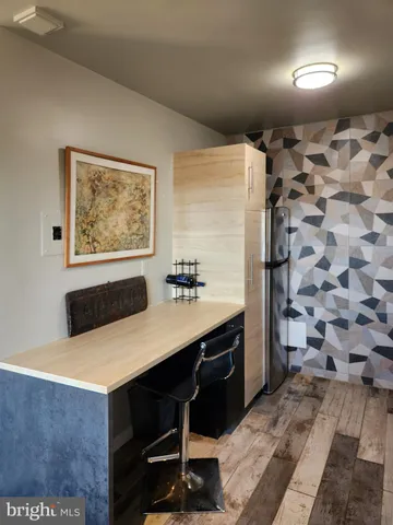 a room with a table chairs and a refrigerator