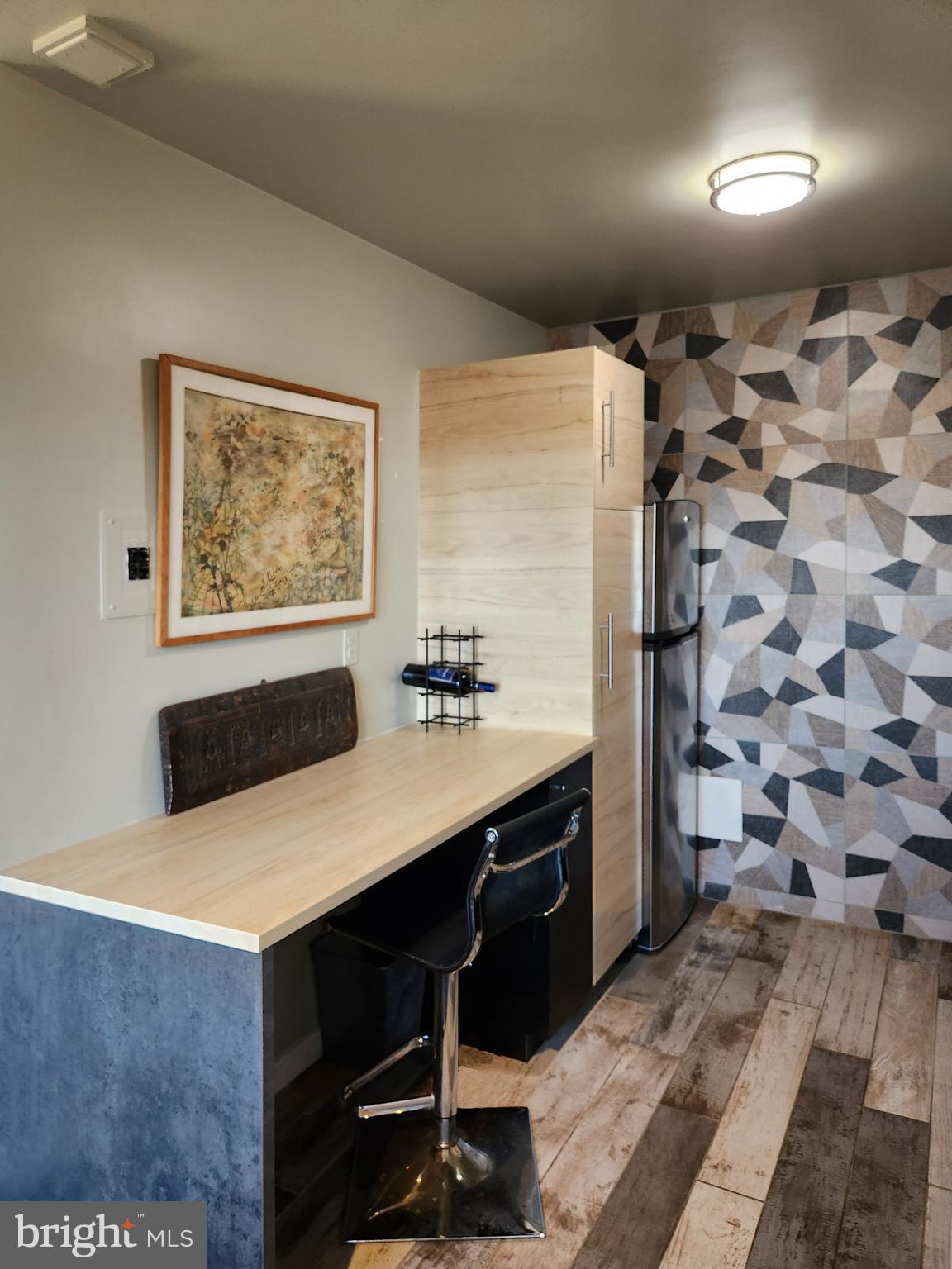 4201 Cathedral Avenue Northwest, Unit 1418E Washington, DC 20016 - Photo 5 of 17 a room with a table chairs and a refrigerator